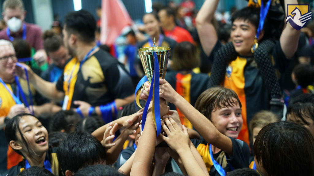 Students hoisting their sports day trophy